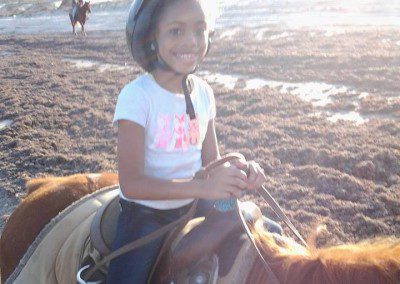 One girls riding horses on the beach