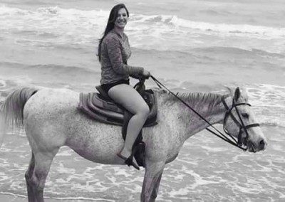 One girl riding horses on the beach